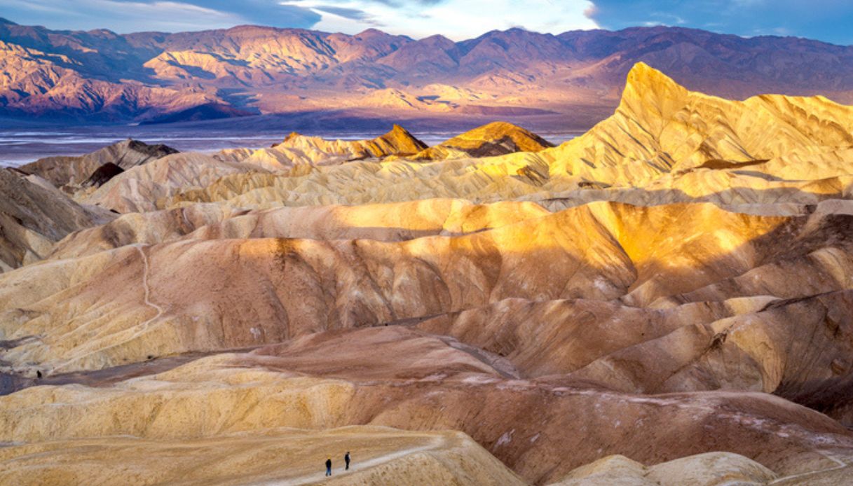 Vista da un punto panoramico della Death Valley, con persone che camminano lungo il sentiero