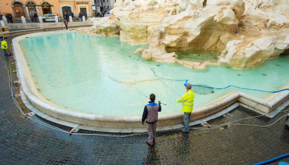 Operai intenti a raccogliere le migliaia di monete gettate nella acqua della Fontana di Trevi dai turisti