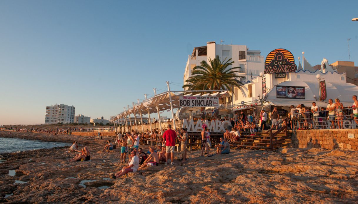 Party in spiaggia ad Ibiza al tramonto, con la bassa marea
