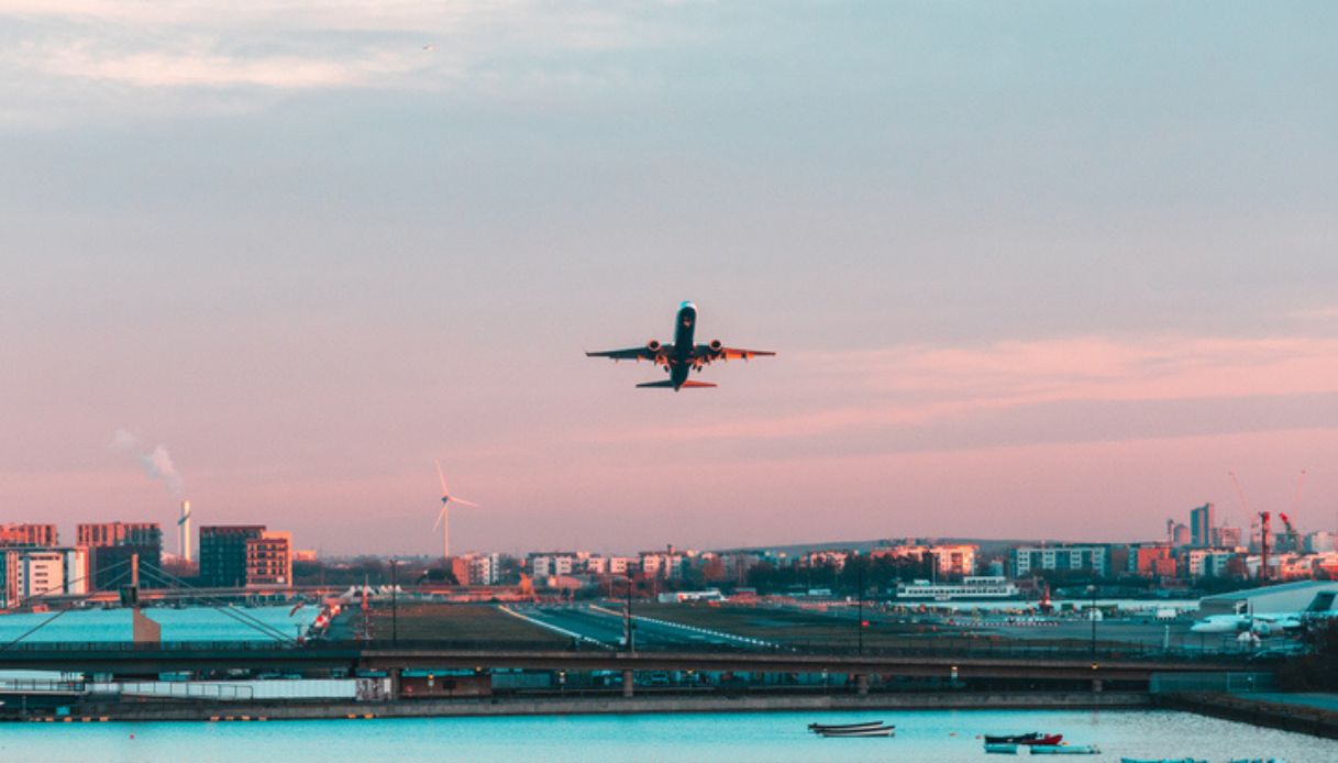 Aereo in fase di decollo dalla città di Londra al tramonto