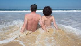 Coppia di nudisti in spiaggia