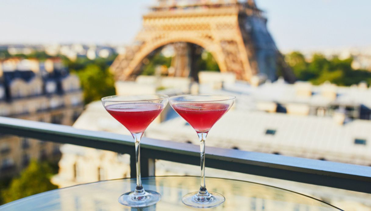 Due bicchieri da cocktail da un rooftop di Parigi con vista della Torre Eiffel sullo sfondo al tramonto