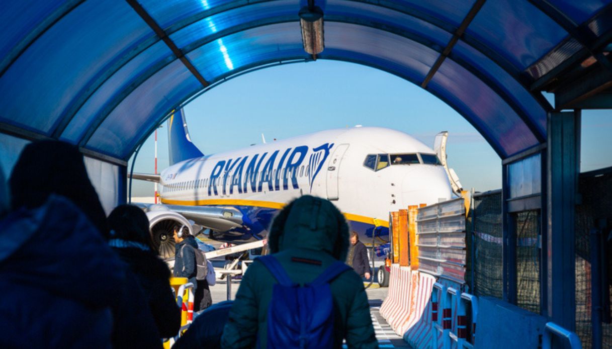 Persone in coda con il proprio bagaglio a mano mentre si imbarcano su un aereo della compagnia Ryanair