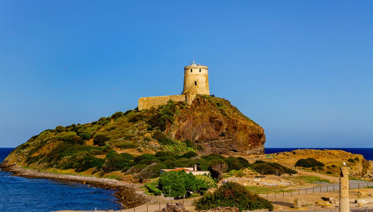 Torre del Castellazzu, una delle torri di avvistamento nei pressi di Pula, che si affaccia sul mare azzurro al tramonto