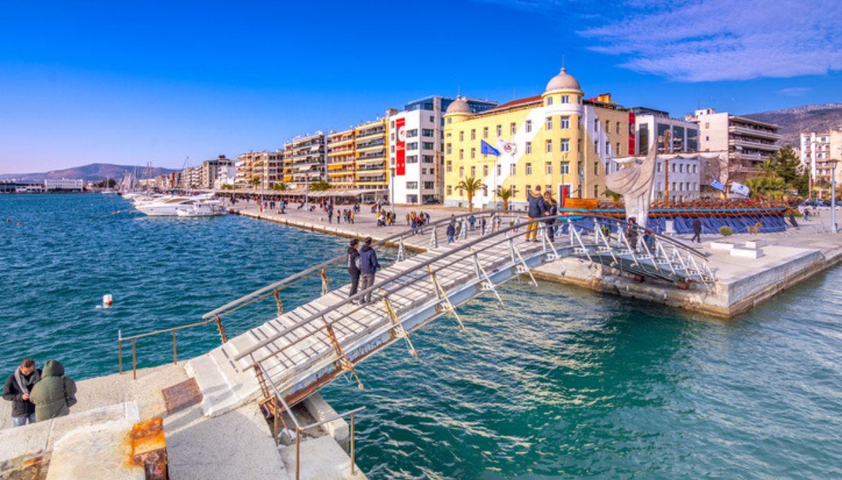 Lungomare di Volos, in Grecia, con costruzioni sullo sfondo ed un ponticello in primo piano