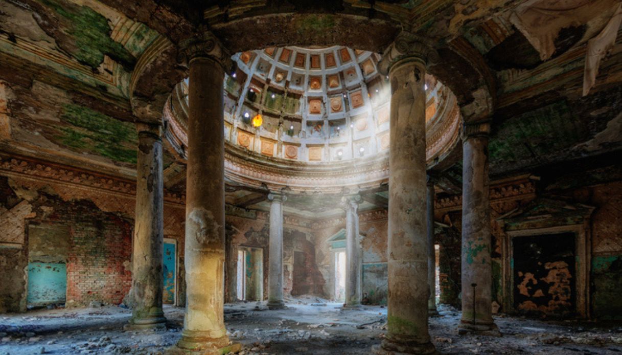 Parte di un vecchio palazzo abbandonato ormai in rovina, con luce che entra dalla cupola