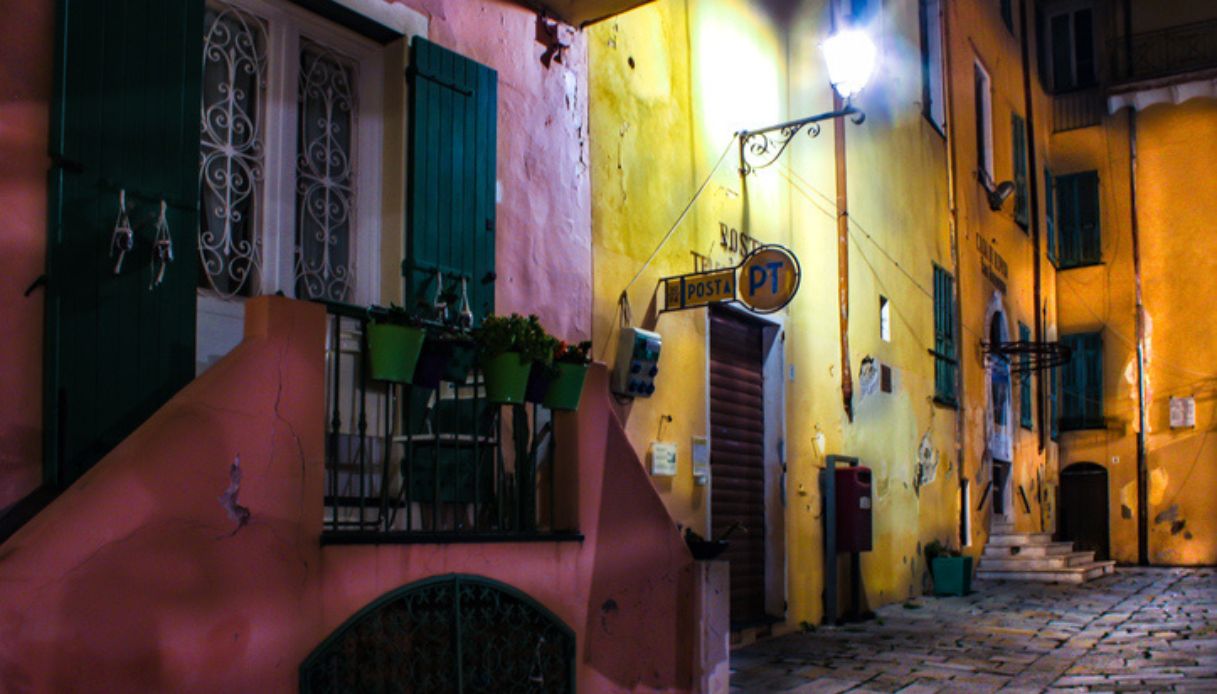 Centro storico di Bordighera durante la notte, con luci accese e vecchi palazzi colorati