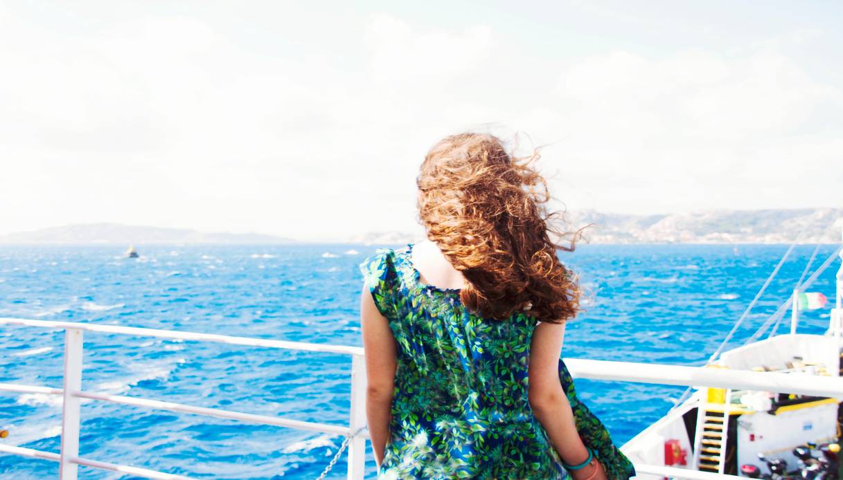 Viaggiatrice che guarda la costa della Sardegna dal ponte della nave