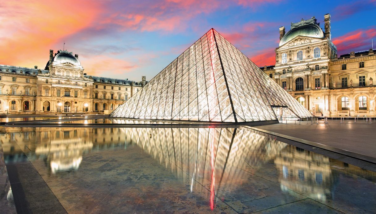 La suggestiva piramide del museo del Louvre illuminata al tramonto