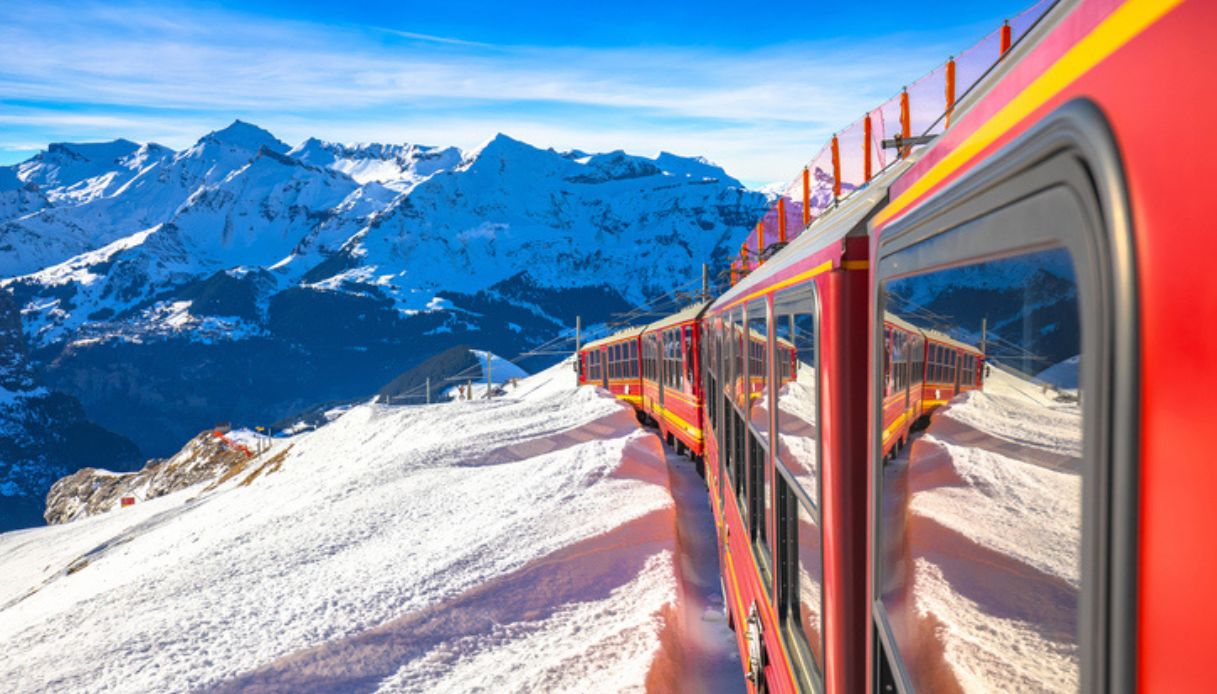 Treno rosso che porta alla stazione di Jungfraujoch sulle alpi svizzere in un paesaggio innevato