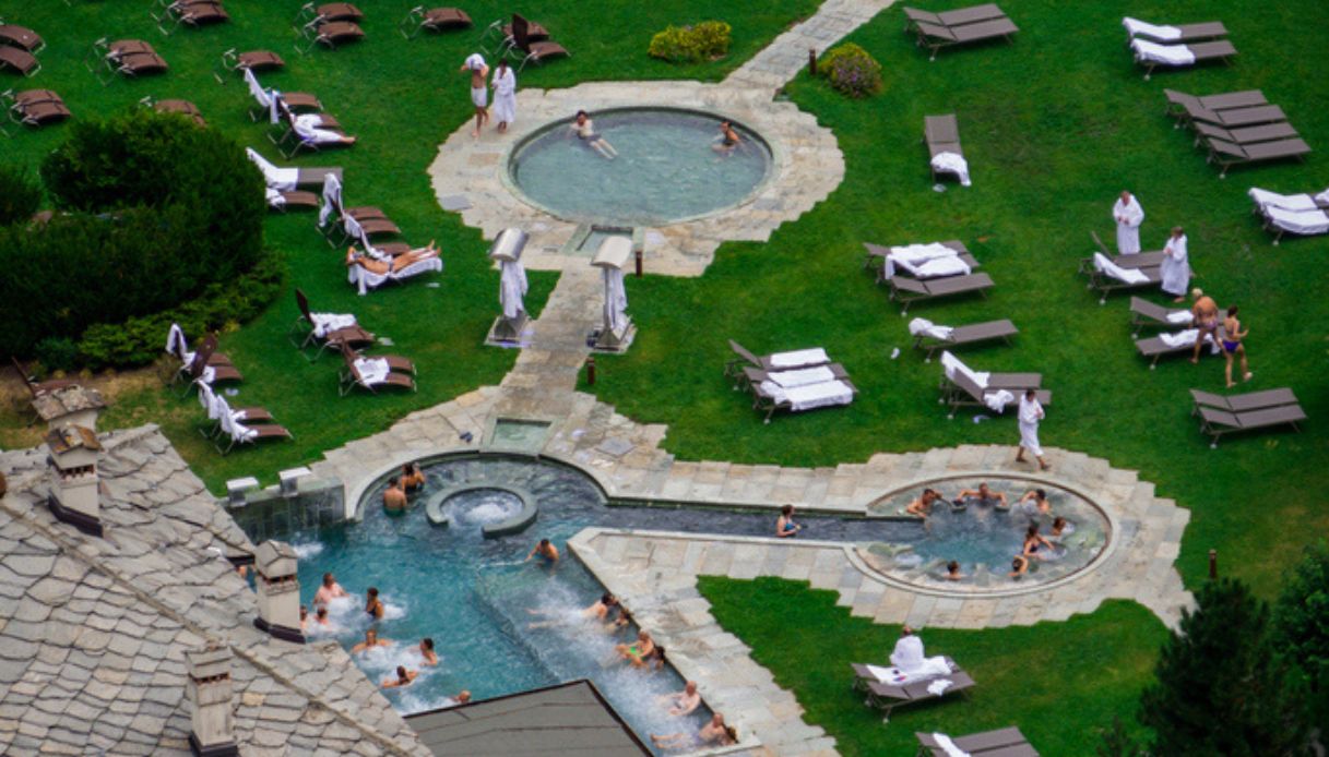 Vista delle piscine esterne del centro termale di Pre Saint Didier, con ospiti del centro fuori e dentro le acque termali