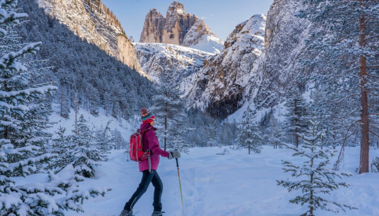 Ciaspolata con sullo sfondo le Tre Cime di Lavaredo, vicino Cortina d'Ampezzo, una delle migliori destinazioni in montagna d'Italia