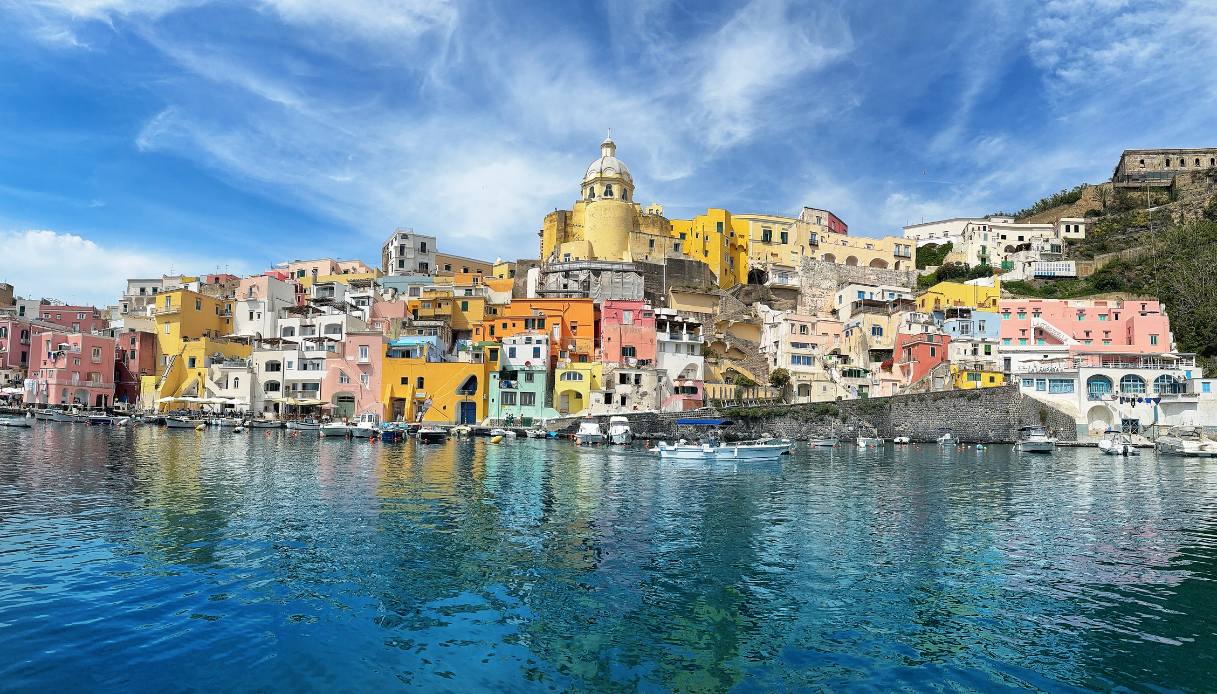 Casette colorate di Procida si riflettono sul mare