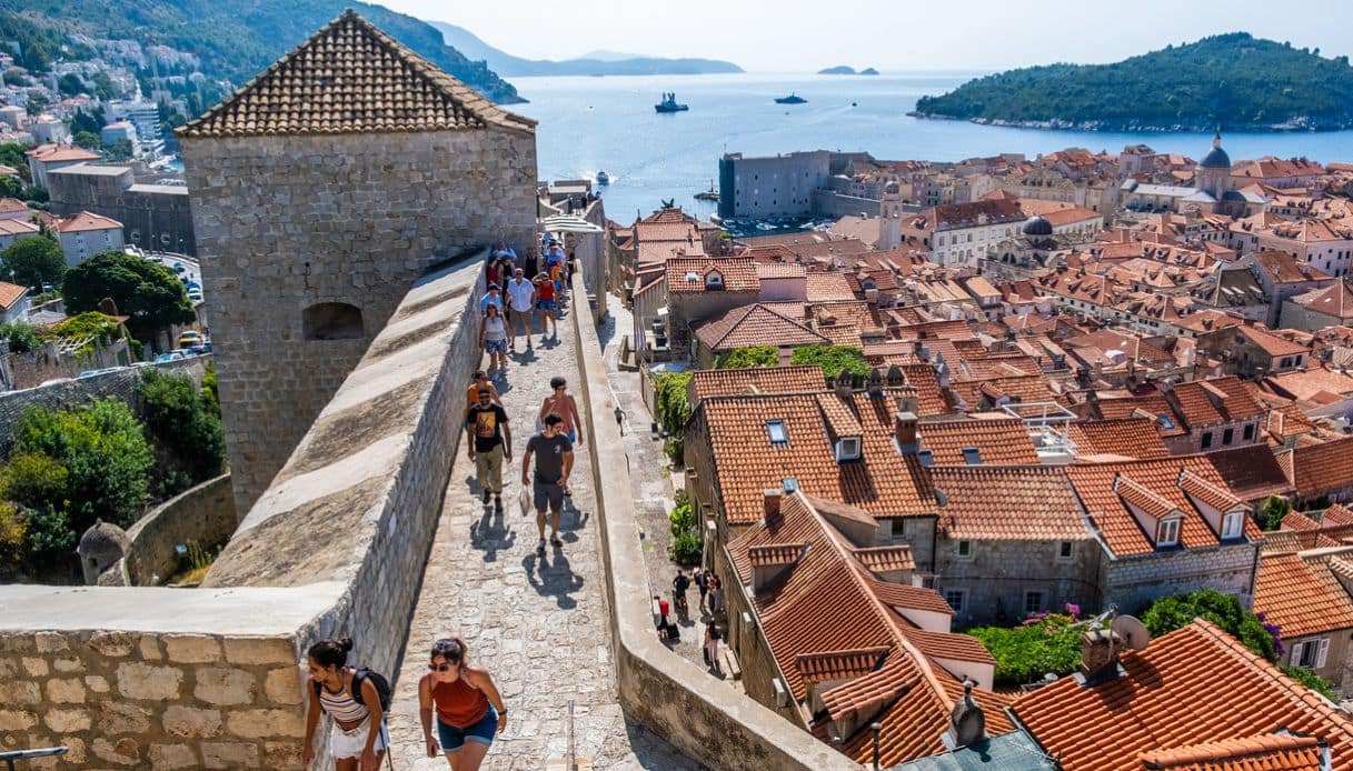 Turisti esplorano le mura della città di Dubrovnik