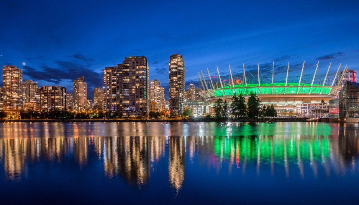Stadio BC Place illuminato con lo skyline di Vancouver