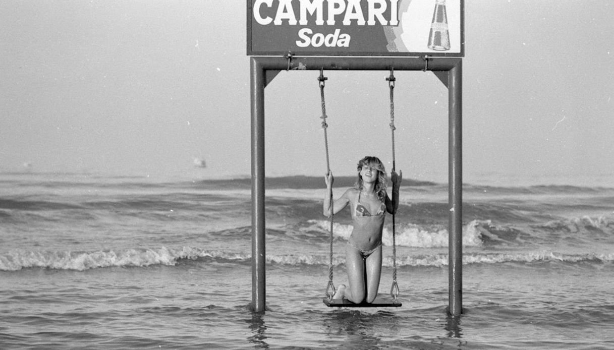 Donna dondola sull'altalena sul mare a Rimini