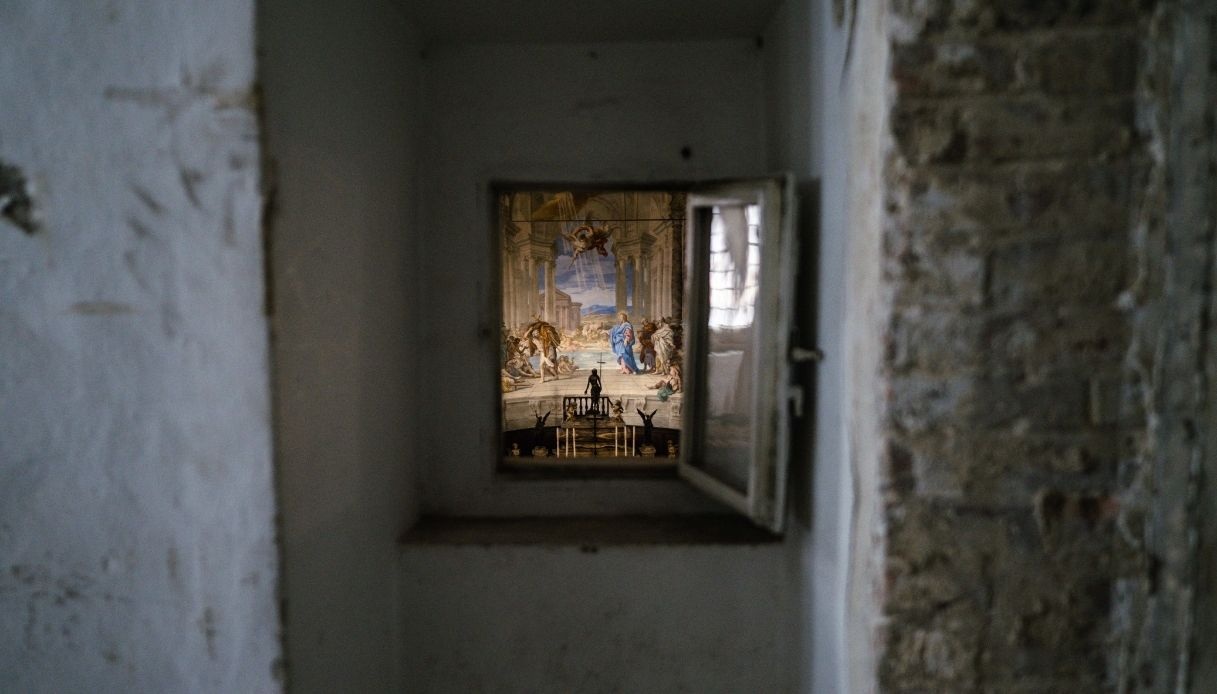 Vista attraverso una piccola finestra su un affresco raffigurante una scena religiosa